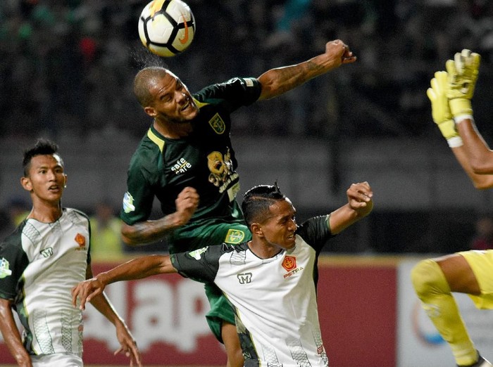 Pesepak bola Persebaya Surabaya David Aparecido Da Silva (kedua kiri) berebut bola dengan pesepak bola PS Tira Muhammad Abduh Lestaluhu (tengah) dalam lanjutan Liga 1 Indonesia 2018 di Gelora Bung Tomo (GBT) Surabaya, Jawa Timur, Selasa (11/9).  ANTARA FOTO/M Risyal Hidayat/foc/18.