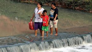Potret Warga Nekat Sebrangi Kanal Banjir Timur