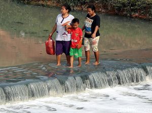 Potret Warga Nekat Sebrangi Kanal Banjir Timur