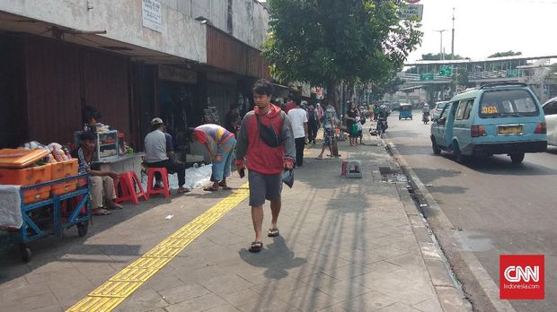 Pejalan kaki melintasi deretan lapak PKL di dekat Pasar Jatinegara, Jaktim, Rabu (17/10).