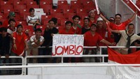 Beberapa suporter timnas Indonesia membentangkan poster bertuliskan Siapa Kita Jomblo di tribun Stadion GBK.