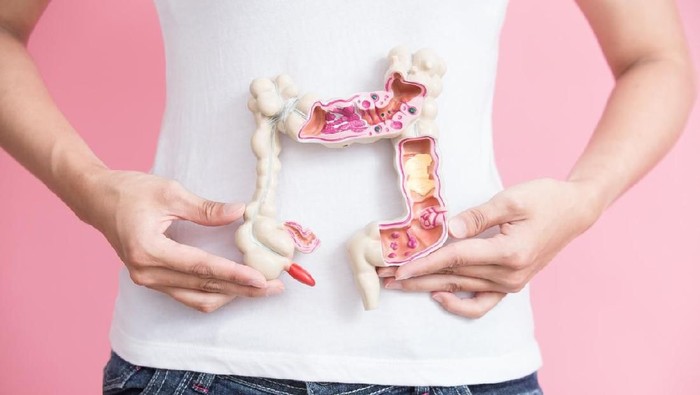 woman with colorectal cancer concept on the pink backgorund