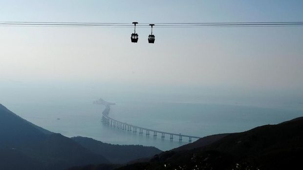 Cable cars move in front of the Hong Kong-Zhuhai-Macau bridge off Lantau island in Hong Kong, China October 21, 2018, before its opening ceremony on October 23, 2018. Picture taken October 21, 2018.    REUTERS/Bobby Yip