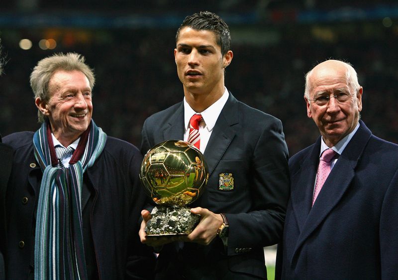 MANCHESTER, UNITED KINGDOM - DECEMBER 10: Cristiano Ronaldo (C) of Manchester United receives the Ballon d'or as the European Footballer of the Year flanked by previous winners Denis Law (L) and Bobby Charlton before the UEFA Champions League Group E match between Manchester United and Aalborg at Old Trafford on December 10, 2008 in Manchester, England. (Photo by Alex Livesey/Getty Images)