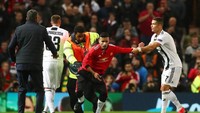 Setelah pertandingan tuntas ada suporter lain yang masuk ke lapangan mendekati Ronaldo. Fans itu juga langsung diamankan, tapi Ronaldo mencoba menahannya (REUTERS/Hannah McKay)