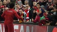 Saat akan menuju lorong ganti pemain usai laga tuntas, Mohamed Salah mendatangi seorang fans yang berada di tepi tribun penonton. Suporter wanita itu membawa sebuah syal dengan huruf arab tertulis di atasnya (Michael Regan/Getty Images)