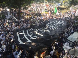 Massa Bentangkan Bendera Berkalimat Tauhid Raksasa di Medan Merdeka