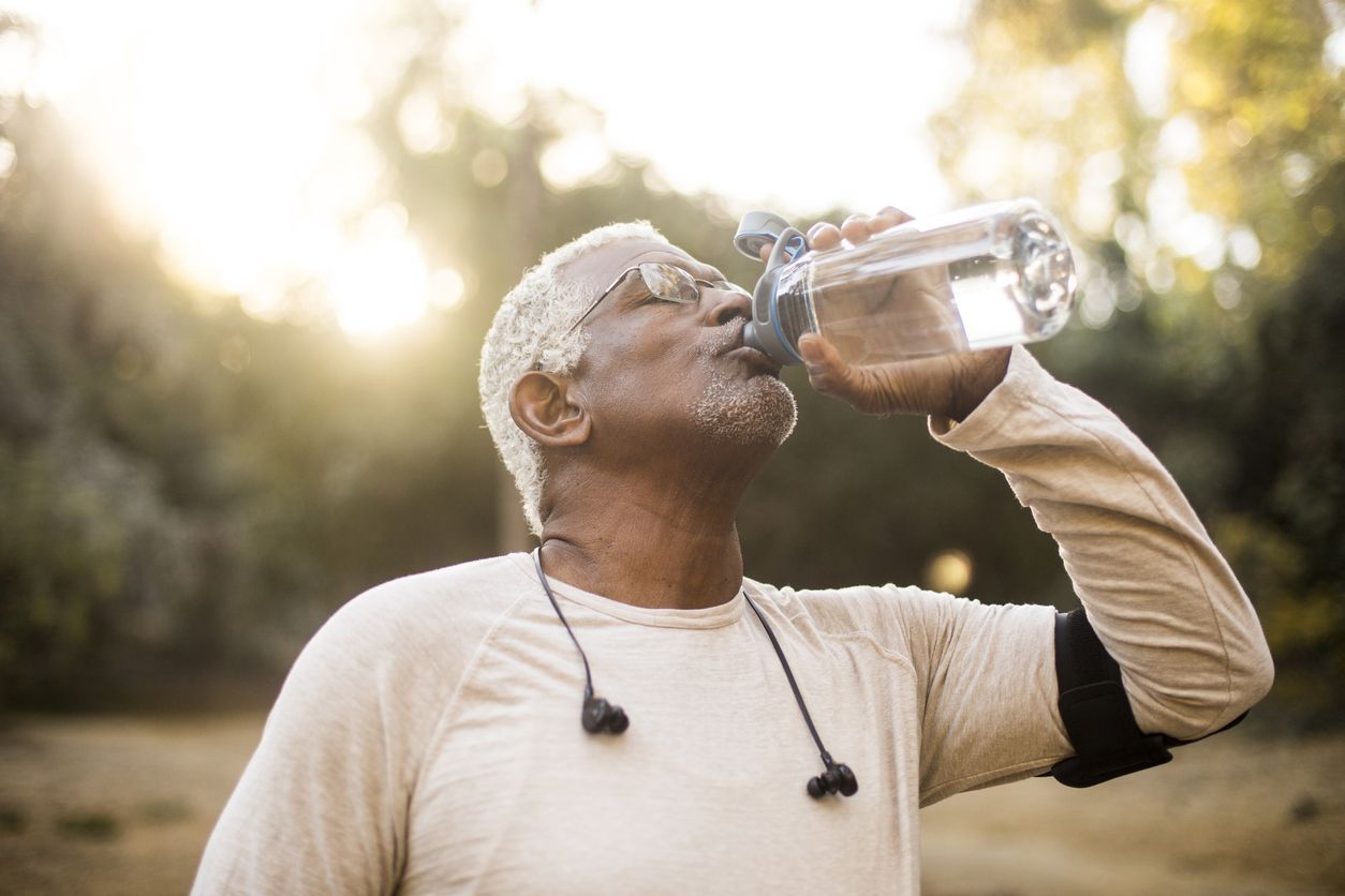 A child is drinking clean water from a bottle. Hot summer day.