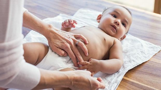 Ilustrasi bayi dipakaikan popok