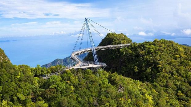 amazing cable bridge over the tropical rainforest island landscape in langkawi, malaysia.