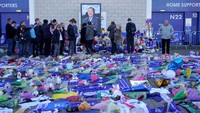 Ribuan bunga dan ornamen bernuansa biru khas Leicester bertebaran di sekitar stadion untuk melepas sang pemilik. Foto Vichai juga terpasang rapi, di mana para suporter berdoa di depannya. (Foto: Christopher Furlong/Getty Images)