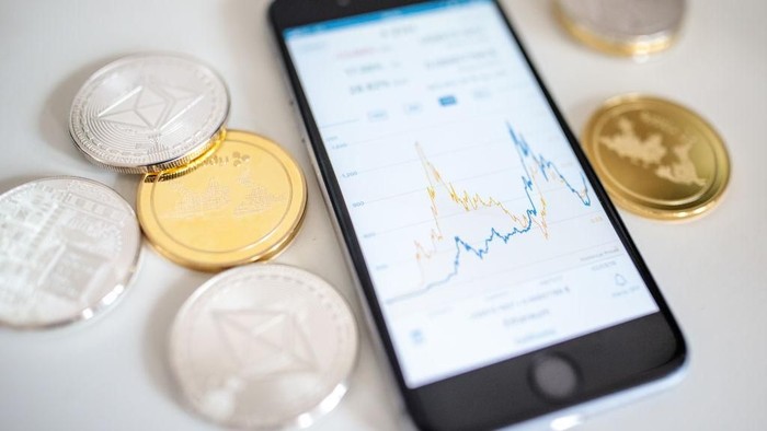 Ilustrasi Cryptocurrency, Cryptocurrency LONDON, ENGLAND - APRIL 25: In this photo illustration of the litecoin, ripple and ethereum cryptocurrency altcoins sit arranged for a photograph beside a smartphone displaying the current price chart for ethereum on April 25, 2018 in London, England. Cryptocurrency markets began to recover this month following a massive crash during the first quarter of 2018, seeing more than $550 billion wiped from the total market capitalisation. (Photo by Jack Taylor/Getty Images)