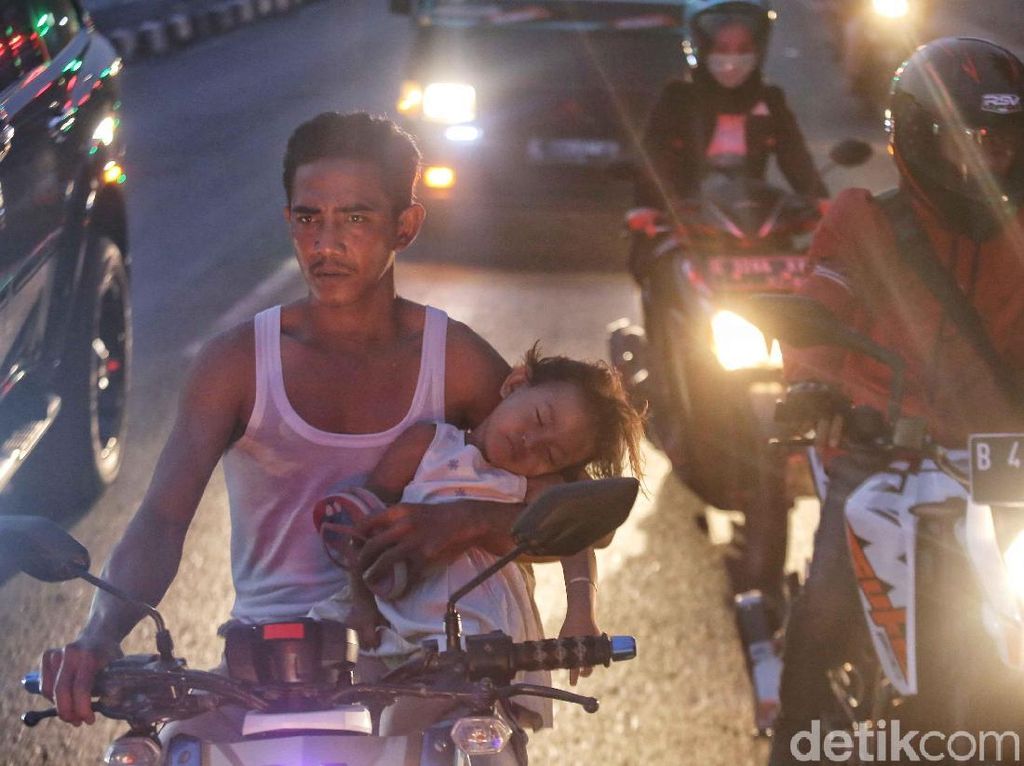 Waduh, Bapak Ini Naik Motor Sambil Menggendong Anaknya yang Tidur