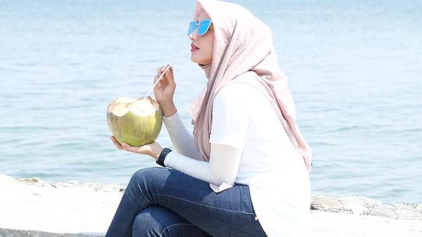 Cantiknya Dokter Nadia Alaydrus Saat Minum Es Kelapa di Pinggir Pantai