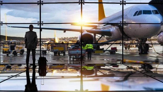 Passenger airplane getting ready for flight and business man waiting to board a flight in airport