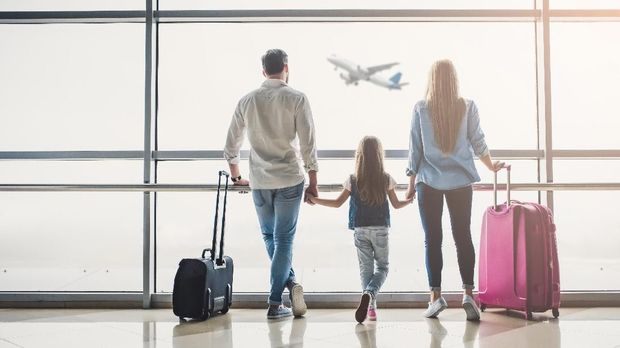 Family in airport. Attractive young woman, handsome man and their cute little daughter are ready for traveling! Happy family concept.