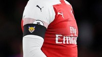 Para pemain Arsenal mengenakan ban hitam di lengan sebagai tanda belasungkawa. Ban hitam ini berlogo Leicester City. (David Klein/REUTERS)