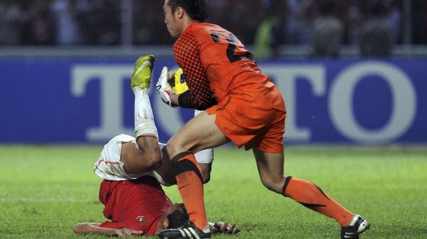 Malaysia's goalkeeper Khairul Fahmi (C) saves the ball from Indonesia's wing back Arif Suyono during their second leg final of the AFF Suzuki Cup 2010 in Jakarta on December 29, 2010. AFP PHOTO / ADEK BERRY (Photo by ADEK BERRY / AFP)