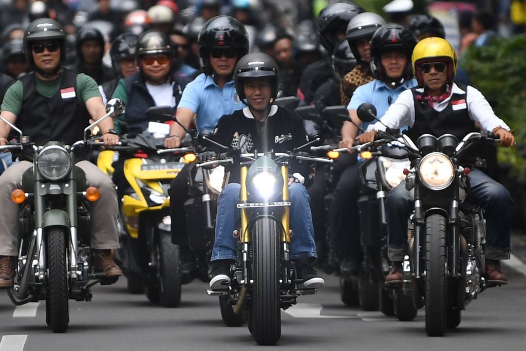 Presiden Joko Widodo (tengah) didampingi Gubernur Jawa Barat Ridwan Kamil (kedua kiri) dan komunitas mengendarai sepeda motor mengelilingi Bandung, Jawa Barat, Minggu (11/11/2018). Kegiatan tersebut merupakan rangkaian Deklarasi Jabar Kondusif yang diikuti 195 komunitas untuk menjaga suasana yang nyaman dan aman guna menjaga persatuan dan kesatuan bangsa. ANTARA FOTO/Wahyu Putro A/nz.