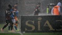 Hujan yang semakin deras membuat wasit memutuskan untuk menghentikan pertandingan di menit ke-59. Foto: Paolo Rattini/Getty Images