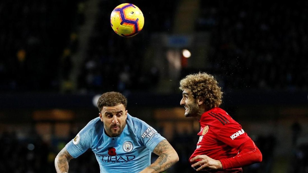 Kyle Walker dan Marouane Fellaini tengah ebrebut bola dalam derby manchester tadi malam. (Darren Staples/Reuters)