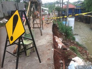 Petugas Perbaiki Jalan Longsor di Setu Cipayung Arah Bekasi