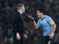 Luis Suarez memprotes keputusan wasit. Reuters/Peter Cziborra.