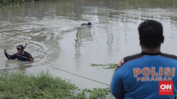 Petugas dari Polda Metro Jaya menerjunkan penyelam untuk mencari linggis yang digunakan tersangka HS untuk menghabisi satu keluarga di Bekasi, di sungai Kalimalang, (17/11).