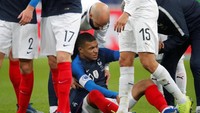 Kylian Mbappe mendapat pertolongan dari tim medis Les Bleus usai terjatuh. (Charles Platiau/Reuters)
