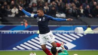 Kylian Mbappe tampak menghindari terjangan kiper Uruguay Martin Campana dalam duel satu lawan satu di kotak penalti. (Benoit Tessier/REUTERS)