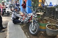 Petugas Dishub Kota Bandung mencabut pentil sepeda motor yang parkir di trotoar.
