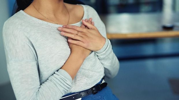 Closeup shot of an unidentifiable businesswoman holding her chest in pain