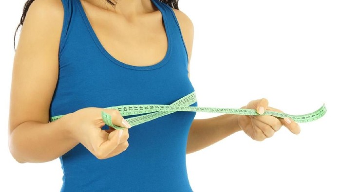 ilustrasi payudara young woman is measuring her breast