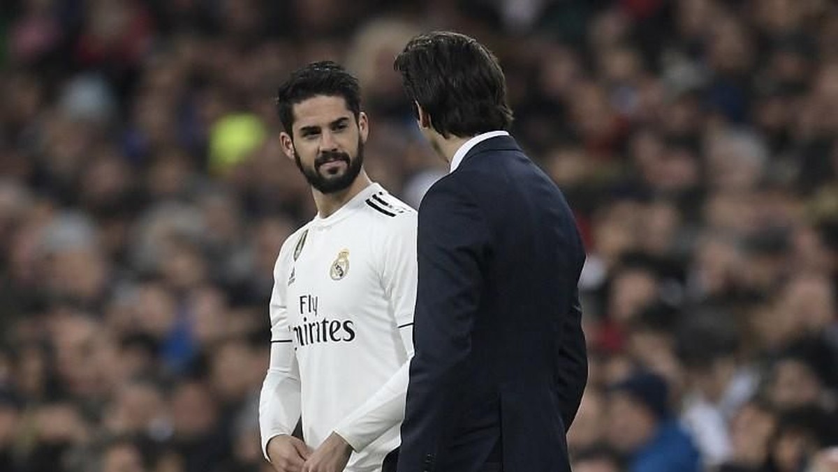 Gelandang Real Madrid Isco berbincang sejenak dengan Santiago Solari sebelum bermain melawan Valencia. (Foto: OSCAR DEL POZO/AFP)