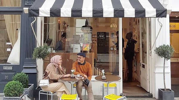 Pose Cantik Desainer Busana Muslim Ria Miranda Saat Ngopi dan Makan Kue