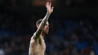 Kapten Sergio Ramos melepas jersey dan melambaikan tangan ke fans. Kemenangan atas Valencia membuat Madrid kini mengoleksi 25 poin di posisi lima, mendekati Sevilla yang berada di posisi pertama dengan 26 poin, dan Barcelona di tempat kedua dengan 25 angka.. Kedua rivalnya itu baru akan bermain malam nanti. (Foto: Sergio Perez/Reuters)