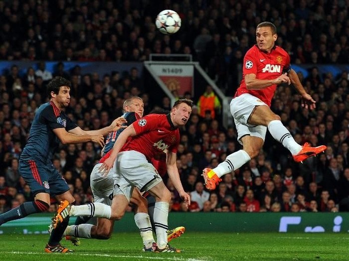 Manchester Uniteds Serbian defender Nemanja Vidic (R) scores the opening goal during the UEFA Champions League quarter-final first leg football match between Manchester United and Bayern Munich at Old Trafford in Manchester on April 1, 2014.  AFP PHOTO / ANDREW YATES (Photo by ANDREW YATES / AFP)