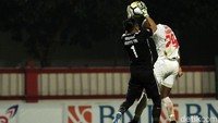 Kiper Bhayangkara FC mengamankan bola dari tandukan pemain PSM.