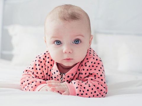 Cute baby girl on the white bed