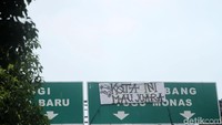 Sayangnya ada juga spanduk yang dipasang menutupi papan petunjuk arah jalan.