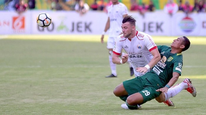 Pesepak bola Persebaya Surabaya Mokhamad Syaifuddin (kanan) berebut bola dengan pesepak bola Persija Jakarta Marko Simic (kiri) dalam lanjutan Liga 1 Indonesia di Stadion Gelora Bung Tomo (GBT) Surabaya, Jawa Timur, Minggu (4/11/2018). Persebaya Surabaya kalahkan Persija Jakarta dengan skor 3-0. ANTARA FOTO/M Risyal Hidayat/foc.