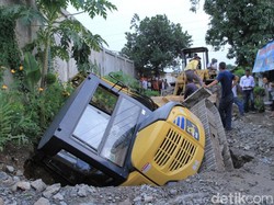 Alat Berat yang Menguruk Jalan Berlubang di Kutawaringin Ambles