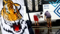 Suporter Persija Jakarta, The Jakmania, mencuci bus transjakarta di kantor PT Transjakarta, Cawang, Jakarta, Kamis (13/12/2018).