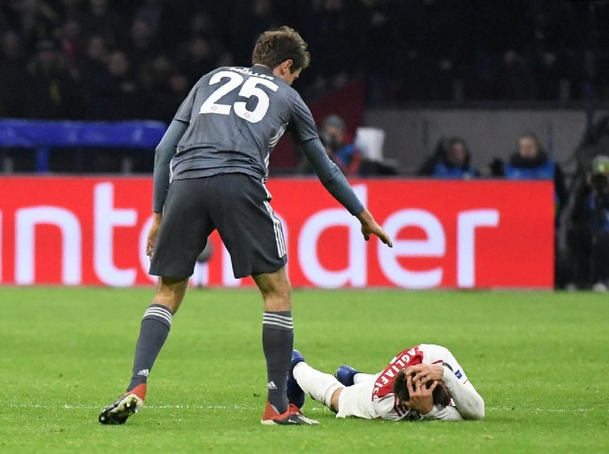 Thomas Mueller meminta maaf usai menerjang kepala Nicola Tagliafico di laga Ajax vs Bayern Munich. (Foto: Piroschka van de Wouw/Reuters)