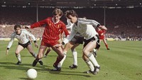 Liverpool dan MU berhadapan di final Piala Liga Inggris 1983. Striker THe Reds, Kenny Dalglish, berduel dengan Kevin Moran dalam laga di Stadion Wembley. (Allsport/Getty Images)