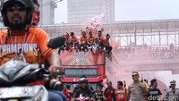 Mereka menyambut para pemain Persija yang diarak dengan bus terbuka.