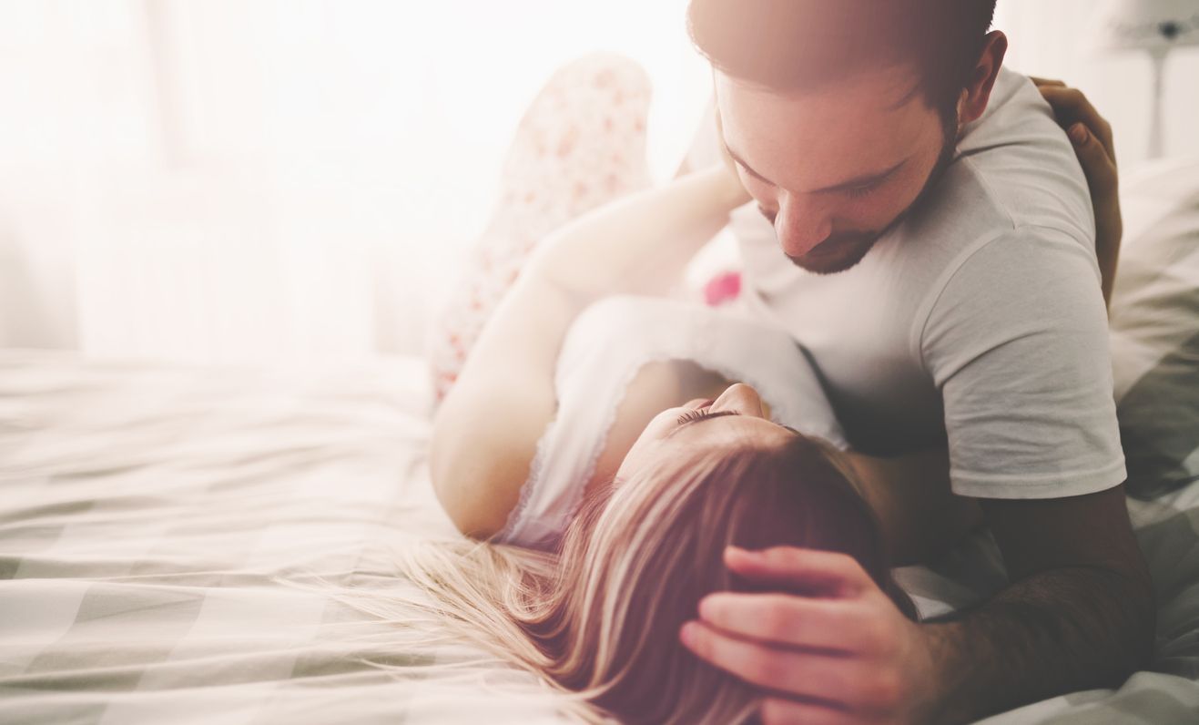 Sensual romantic foreplay by couple in love in bed