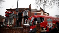 Suporter Liverpool menyambut kedatangan bus yang membawa seluruh pemain untuk laga kontra Manchester United di Anfield, Minggu (16/12/2018) malam WIB. (Carl Recine/Reuters)