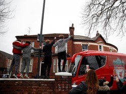 Suporter Liverpool menyambut kedatangan bus yang membawa seluruh pemain untuk laga kontra Manchester United di Anfield, Minggu (16/12/2018) malam WIB. (Carl Recine/Reuters)