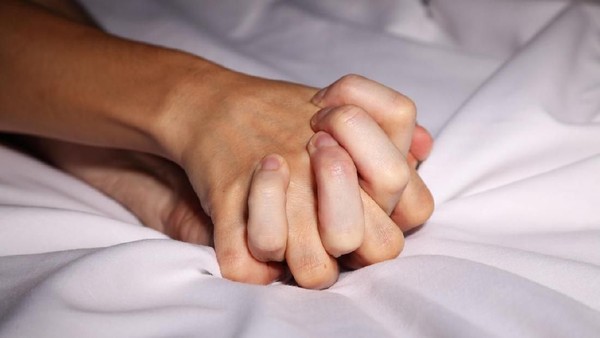 ilustrasi pasangan Couple in bed holding hands passionately